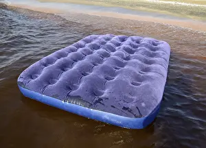 Blue inflatable mattress swimming in the pond
