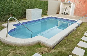 A blue swimming pool with a sand suction hose