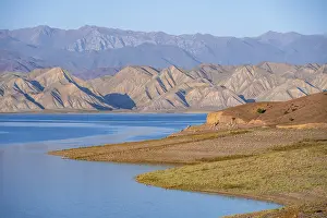 Blue Toktogul reservoir between dry mountain landscape