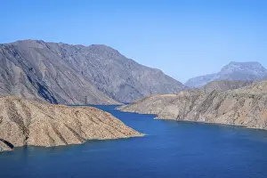 Blue Toktogul reservoir between dry mountain landscape