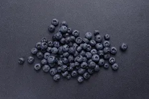Blueberries are scattered on a blue background