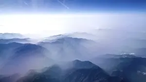 Blurred mountain ranges covered with fog and clouds in the distance