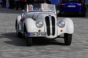 BMW 328 Roadster, white classic car convertible drives across a paved area