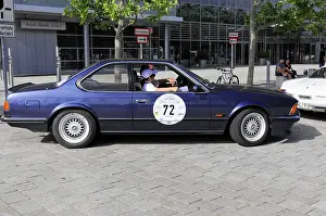 BMW M 635 CSi, classic blue car with driver on a paved city scene