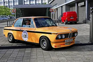 BMW, orange classic car at a rally in the city
