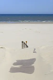 Boardwalk with sand drifts leads to the extensive sandy beach