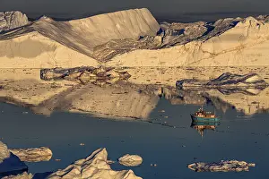 Boat in front of icebergs, reflection