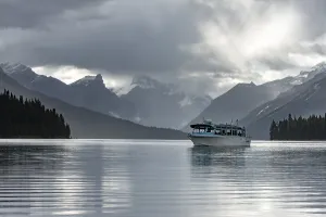 Boat on Maligne Lake, behind it mountain range Queen Elizabeth Ranges with Samson Peak