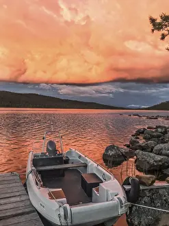 Boat moored on a jetty under a dramatic