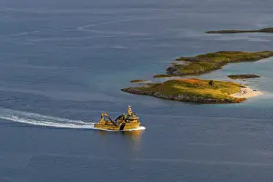 Boat passing islands near Sommaroy Bridge