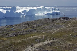 Boats in a bay with huge icebergs