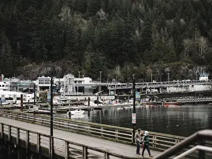 Boats docked alongside a wooden pier with a backdrop of dense forest in Horseshoe Bay