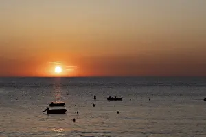 Boats in front of sunset at the sea