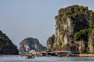 Boats in front of towering limestone cliffs on a clear summer's day