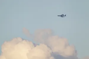 Boeing E-3 Sentry aircraft flying above white clouds in the sky