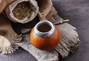 Bombilla with colabash and bag of mate tea on wooden background