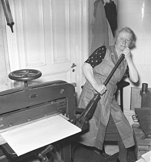 Bookbindery 1947. A lady works at the paper cutting machine. She has the paper sheets arranged to the size she wants and uses her muscle power on a lever to cut them. Kristoffersson ref AF27-1