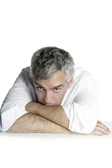 Bored senior businessman on table desk hands crossed white background