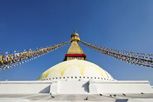 Boudnath Stupa with prayer flags against blue sky