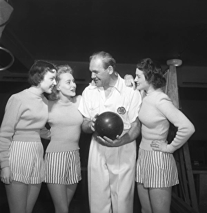Bowling in the 1950s. A man with three young women in a bowling alley