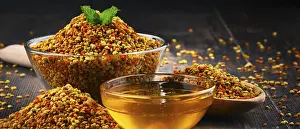 Bowls with bee pollen and honey on kitchen table