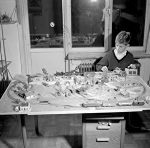 Boy in the 1950s. A boy at his model railroad mounted on a table in his room
