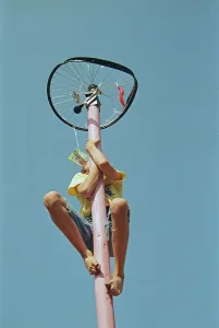 Boy climbs on maypole, barefoot