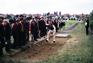 Boy competing in the long jump competition on secondary school sports day, Ilford County High School, Essex, England, 1965
