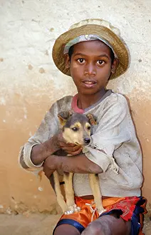 Boy with dog puppy on arm, Madagascar