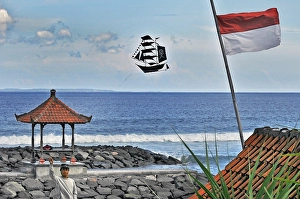 A boy flies a kite in the shape of a ship, Bali, Indonesia, Asia