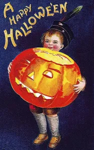 Boy holding a carved pumpkin or Jack-o-lantern in his arms