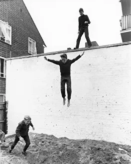 Boy leaps from wall, England, Great Britain