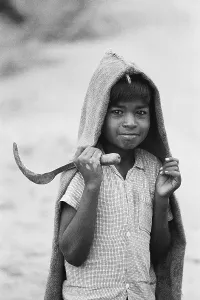 Boy with sickle and jute raincoat Mysore Karnataka India Asia 1977