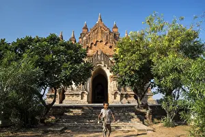 Boy in front of a temple, stupa or pagoda in the temple complex of the Plateau of Bagan