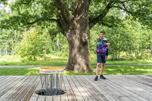 Boy throws a disc at disc golf