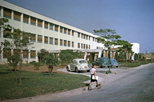 Boy walking on the street, VW Volkswagen Beetle, parked at the university building, Sao Paulo, Brazil, South America 1962, South America