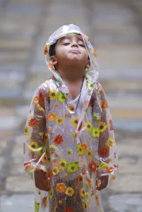 Boy wearing raincoat, India