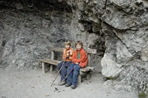 Two boys sitting at the exit of the gorge Partnachklamm near Partenkirchen