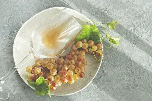 A branch of white grapes, on a gray plate
