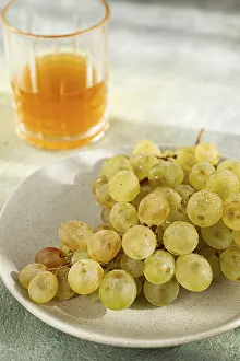 A branch of white grapes, on a gray plate