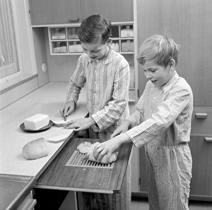Breakfast in the 1950s. Two boys are standing in pajamas preparing breakfast