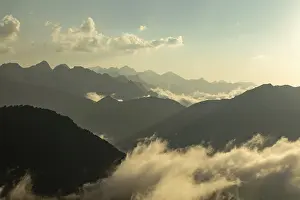 A breathtaking view of mist-covered mountains under a golden sunrise