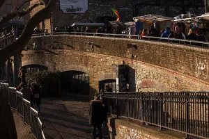 A brick bridge with market stalls and people