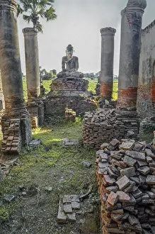 Brick columns of a dilapidated temple with Buddha figure in Amarapura