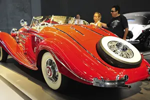 A bright red convertible vintage car at an exhibition