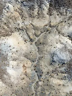 Broken, rocky ground with sparse vegetation