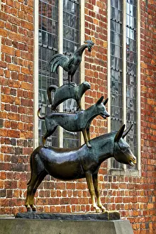 Bronze sculpture of the Bremen Town Musicians in front of a historic brick wall