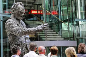 A bronze sculpture of a man stands in a modern building at an exhibition