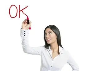 Brunette businesswoman writing word OK on a copyspace