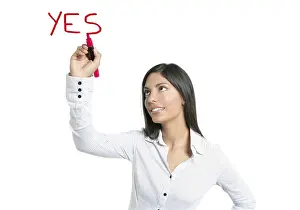 Brunette businesswoman writing word YES on a copyspace
